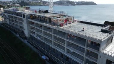 Torquay, Torbay, Güney Devon, İngiltere: DRONE VİEWS: İHA inşaat halindeki yeni bir otelin üzerine yükseliyor ve çatısı ve açık katları gösteriyor. B / g 'de Torbay; Torquay ve Torbay İngiltere' nin popüler tatil beldeleridir (Clip 2).