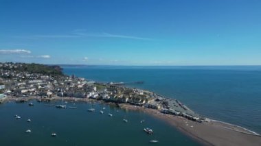 Teignmouth, Güney Devon, İngiltere: DRONE VİEWS: İnsansız hava aracı Teign Nehri 'ni ve Teignmouth kasabasını, rıhtımını ve rıhtımını gösteren denizi çevrelemektedir. Teignmouth hem liman kenti hem de popüler bir İngiliz tatil beldesidir (Clip 2).
