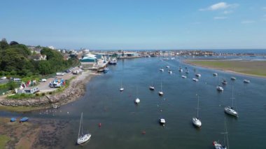 Teignmouth, Güney Devon, İngiltere: DRONE VİEWS: Bir kargo gemisi liman kenarı yükleyicileri tarafından top killeriyle doldurulur. Teignmouth limanı ayrıca hayvan yemi, toplamı ve tuz ithalatı ve ihracatıyla da ilgilenir; kasaba aynı zamanda popüler bir tatil beldesidir (Klip 14).