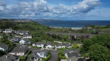 Broadsand, Güney Devon, İngiltere: DRONE VİEWS: Paignton 'a giden bir buhar treni viyadük geçidinden geçiyor. Torbay, İngiltere 'nin popüler bir tatil beldesidir ve Torbay Buhar Demiryolu Hattı bölgenin birçok ve çeşitli turistik merkezlerinden biridir (Clip 1).).
