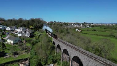 Broadsand, Güney Devon, İngiltere: DRONE VİEWS: Kingswear 'e giden bir buhar treni viyadük geçidinden geçiyor. Torbay Buhar Demiryolu Hattı, İngiltere 'nin popüler tatil beldesi Torbay' da turistler ve tatilciler için önemli bir cazibe merkezi.).