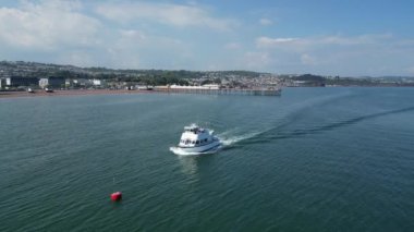 Paignton, Torbay, Güney Devon, İngiltere: DRONE ViEWS: Bir yolcu / turist teknesi kasaba limanını geçtikten sonra Paignton limanına doğru yola çıkıyor. Torbay, pek çok farklı turistik mekanı bulunan popüler bir İngiltere tatil beldesi.. 