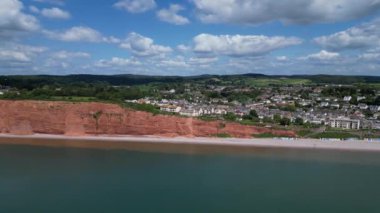 Budleigh Salterton, Doğu Devon, İngiltere: DRONE VİEWS: Dünya Mirası Sahası 'nın bir kısmını oluşturan kırmızı kumtaşı uçurumları ve Budleigh Salterton kasabası. Jurassic Coast popüler bir İngiltere turizm merkezidir (Clip 4).