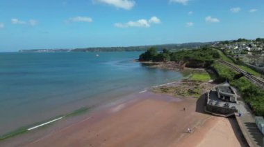 Goodrington Sands, Torbay, Güney Devon, İngiltere: İHA Goodrington Güney Sahili üzerinde uçuyor buharlı demiryolu hattını, sahil kulübelerini, sahil uçurumlarını, yalnız bir gemi ve Berry Head 'i gösteriyor. Torbay İngiltere 'de popüler bir tatil beldesi..