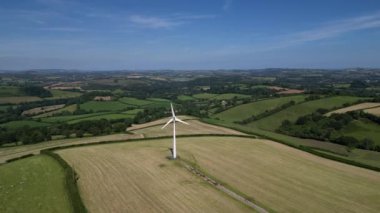 Rattery, Buckfastleigh yakınlarında, Güney Devon, İngiltere: DRone VİEWS: Bir rüzgar türbini çiftlik arazileriyle çevrili. Rüzgar türbinleri, hükümetin ağ sıfır elde etmek için yenilenebilir enerji stratejisinin bir parçasıdır (Klip 1).