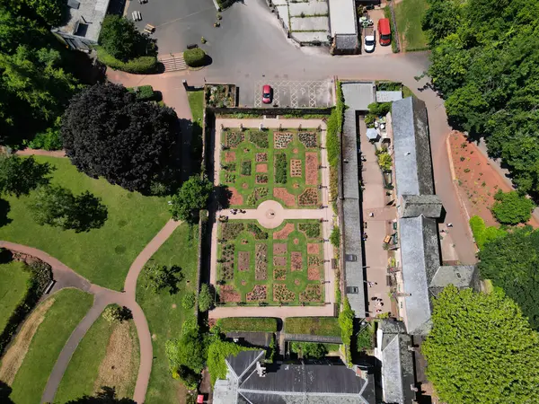 stock image Cockington, Torbay, South Devon, England: DRONE VIEW: An overhead view of a rose garden and surrounding buildings at Cockington Court in Cockington Park. Torbay is a popular UK holiday resort with many attractions including its parks and countryside.