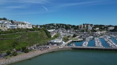 Torquay, Torbay, Güney Devon, İngiltere: DRONE VİEWS: İHA Torquay kasabasının etrafında yükselir ve etrafında daireler çizerek demirli botları ve dönme dolabı gösterir. Torquay, İngiltere 'nin birçok turistik merkezi olan popüler bir tatil beldesidir (2).