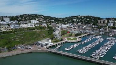 Torquay, Torbay, Güney Devon, İngiltere: DRONE VİEWS: İHA Torquay kasabası ve marinası etrafında döner ve demirli botları ve dönme dolabı gösterir. Torquay, İngiltere 'nin birçok turistik merkezi olan popüler bir tatil beldesidir (1).