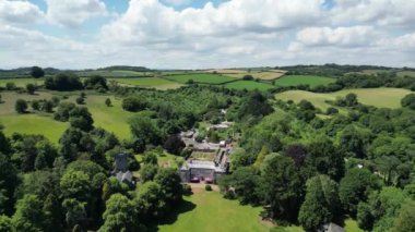 Cockington, Torbay, Güney Devon, İngiltere: DRONE VİEWS: Cockington Park 'ta Cockington Court, St George ve St Mary Church solda. Torbay, kırsal bölgeleri de dahil olmak üzere pek çok ilgi çeken popüler bir İngiltere tatil beldesidir (Clip 3).