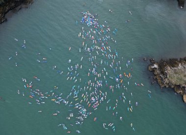 Brixham, Torbay, South Devon, England: DRONE VIEW: Participants gather at Fishcombe Cove as they attempt to beat the World Record for the highest gathering of paddleboarders at sea. Torbay is a hub for tourists and water sports enthusiasts (PHOTO 5). clipart