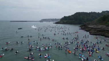 Brixham, Torbay, Güney Devon, İngiltere: DRONE VİEWS: Katılımcılar Fishcombe Cove 'da toplanarak denizdeki en büyük kürek çekme rekorunu kırmaya çalışıyorlar. Torbay, su sporları meraklıları için bir mıknatıstır (Bölüm 8).