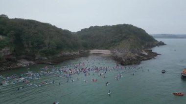 Brixham, Torbay, Güney Devon, İngiltere: DRONE VİEWS: Katılımcılar Fishcombe Cove 'da toplanarak denizdeki en büyük kürek çekme rekorunu kırmaya çalışıyorlar. Torbay, su sporları meraklıları için bir mıknatıstır (Bölüm 1).