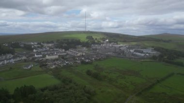 Princetown, Dartmoor Ulusal Parkı, Devon, İngiltere: DRONE VİEWS: Dartmoor Hapishanesi (HMP Dartmoor) de dahil olmak üzere Princetown 'un kenar mahallelerini çevreleyen insansız hava aracı. Princetown yaz aylarında Dartmoor 'dan geçen aylaklar için bir turizm merkezidir (Klip 1).