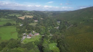 Dartmeet, Dartmoor, Devon, İngiltere: DRONE ViEW: Doğu Dart ve Batı Dart nehirlerinin birleşerek Dart Nehri 'ni oluşturması; insansız hava aracı nehir köprüsünü göstermek için eğilir. Dartmoor Ulusal Parkı popüler bir İngiltere tatil beldesidir (Clip 1).