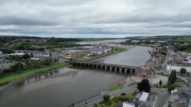 Barnstaple, Kuzey Devon, İngiltere: DRONE VİEWS: İHA merkezi Barnstaple 'deki Taw Nehri boyunca uzanan Uzun Köprü' yü gösteriyor. Ortaçağ köprüsü, kasabanın müreffeh bir yün ticaret merkezi olarak erken tarihini yansıtır (Clip 2).