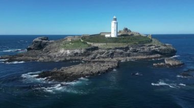 Godrevy Adası, Cornwall, İngiltere: DRone VieWS: Ada ve Godrevy deniz feneri. Godrevy deniz feneri ilk olarak 1 Mart 1859 'da faaliyete başladı ve birçok can alan yakınlardaki Stones Resifi' nden geçen gemileri uyarmak için inşa edildi (Klip 12).