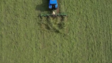 Broadbay, Torbay, Güney Devon, İngiltere: DRONE VİEWS: İHA, sürülen bir tarlada çimleri biçen bir traktörün kuş bakışı görüntüsünü verir. Devon, İngiltere 'de popüler bir tatil beldesidir ve tarım ve çiftlik hayvancılığıyla ünlüdür (Clip 5).