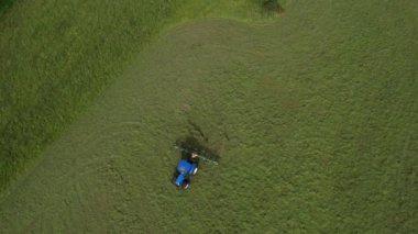 Broadbay, Torbay, Güney Devon, İngiltere: DRONE VİEWS: İHA, sürülen bir tarlada çimleri biçen bir traktörün kuş bakışı görüntüsünü verir. Devon, İngiltere 'de popüler bir tatil beldesidir ve tarım ve çiftlik hayvancılığıyla ünlüdür (Clip 1).