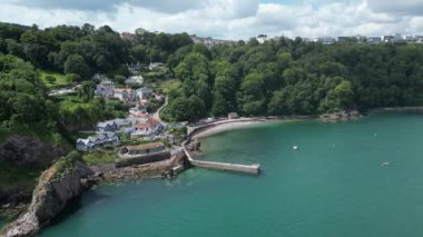 Babbacombe, Güney Devon, İngiltere: DRONE VİEWS: Babbacombe liman duvarı ve sahile bakan mülkler etrafında döner. Babbacombe güzel kıyı şeridiyle tanınan popüler bir İngiltere tatil beldesidir (Clip 4).