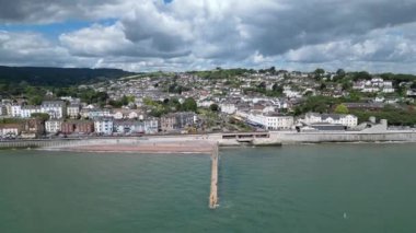 Dawlish, Güney Devon, İngiltere: DRONE VIEWS: Arka planda Dawlish kasabası, drone kamerasının kasabanın rıhtımına eğilmesi olarak görülüyor; orta kısımda plaj ve ana hat tren yolu yer alıyor. Dawlish İngiltere 'de popüler bir tatil beldesidir (1).