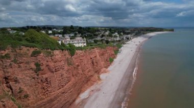 Budleigh Salterton, Doğu Devon, İngiltere: DRONE VİEWS: Dünya Mirası Jurassic Sahili 'nin bir kısmını oluşturan kırmızı kumtaşı uçurumları; arka planda Budleigh Salterton kasabası. Jurassic Coast popüler bir İngiltere turizm merkezidir (Clip 7).