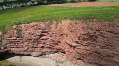 Budleigh Salterton, Doğu Devon, İngiltere: DRONE VİEWS: İHA, Jurassic Coast 'ta popüler bir tatil yeri olan Budleigh Salterton kasabası yakınlarındaki kırmızı kumtaşı uçurumları ve Nehir Samuru' nu ortaya çıkarmak için yükselir (Bölüm 1)).