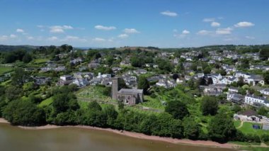 Stoke Gabriel, Güney Devon, İngiltere: İHA, arka planda Stoke Gabriel 'in köy evlerinin bulunduğu Mill Pond üzerinde St Mary & St Gabriel kilisesine odaklanan daireler çiziyor. Güney Devon popüler bir İngiltere tatil beldesidir (Clip 2).