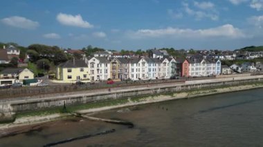 Dawlish, Güney Devon, İngiltere: İHA, Viktorya döneminden kalma bir dizi teras evine odaklanarak kıyı şeridi üzerinde daireler çiziyor; bir şehirlerarası tren, bir deniz duvarı tarafından savunulan bir raydan geçiyor. Dawlish, İngiltere 'de popüler bir tatil beldesi..