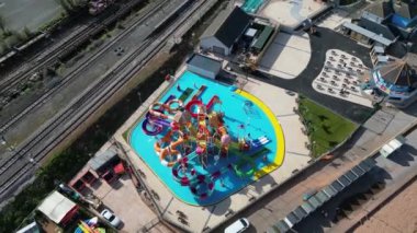 Goodrington Sands, Güney Devon, İngiltere: DRONE VİEWS: İnsansız hava aracı korsan temalı yeni bir hava aracı ve yakınlardaki buharlı tren yolunu gösteriyor. Torbay, çok çeşitli ziyaretçi çekimleri bulunan popüler bir İngiltere tatil beldesidir (Clip 2).