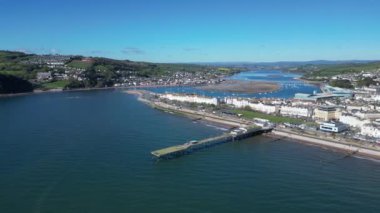 Teignmouth, Güney Devon, İngiltere: DRONE VİEWS: İHA arka planda Teign Nehri ile Grand Pier ve Teignmouth sahil şeridinde daireler çiziyor. Teignmouth hem bir liman şehri hem de popüler bir İngiltere tatil beldesidir (Clip 2).