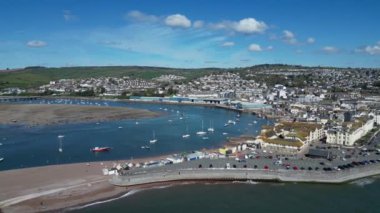 Teignmouth, Güney Devon, İngiltere: İHA, Teignmouth, Teignmouth, Teign Nehri, Teignmouth Rıhtımı ve Shaldon Köprüsü 'nü gösteren Teignmouth sahil şeridinde daireler çiziyor. Teignmouth bir liman kenti ve popüler bir İngiltere tatil beldesidir..