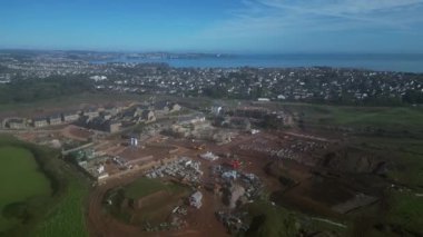 Paignton, Torbay, Güney Devon, İngiltere: DRONE ViEWS: İnsansız hava aracı yeşil kuşak arazisinde yapım aşamasında olan yeni bir konut inşaatı etrafında daireler çiziyor. Bu Inglewood 'un gelişiminin ikinci aşaması. Paignton, İngiltere 'de popüler bir tatil beldesidir.).