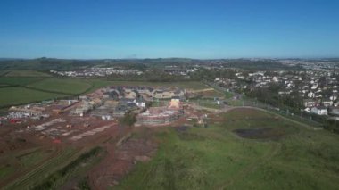 Paignton, Güney Devon, İngiltere: DRONE VİEWS: İnsansız hava aracı yeşil kuşak arazisinde yapım aşamasında olan yeni bir konut geliştirme etrafında daireler çiziyor. Bu Inglewood 'un gelişiminin ikinci aşaması. Paignton İngiltere 'de popüler bir tatil beldesidir (Clip 2).