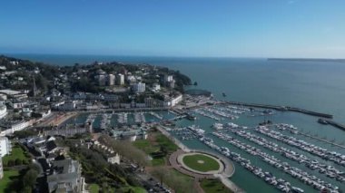 Torquay, Torbay, Güney Devon, İngiltere: DRONE VİEWS: İHA eğilir ve Torquay Marina 'ya doğru uçar yüzlerce gemi ve yat gösterir. Torquay, İngiltere 'de popüler bir tatil beldesi ve yelken meraklıları için bir mıknatıs.).
