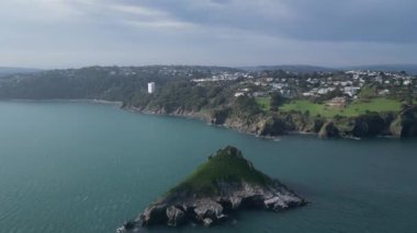 Torquay, Torbay, Güney Devon, İngiltere: DRONE VİEWS: İHA, kıyı şeridini ve Torquay banliyölerini göstererek Thatcher Kayası 'na doğru uçuyor. Torbay İngiltere 'de popüler bir tatil beldesi..