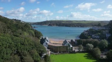 Salcombe, Güney Devon, İngiltere: DRONE VİEWS: İHA Salcombe limanına doğru South Sands 'deki pahalı dairelerin üzerinden uçuyor. Salcombe, İngiltere 'nin en popüler tatil beldesidir ve İngiltere' deki en yüksek ortalama emlak fiyatlarından birine sahiptir..