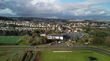 Paignton, Torbay, Güney Devon, İngiltere: DRONE VieWS: Torbay VeloPark 'ta, arka planda Torbay silueti ve Torbay kıyı şeridi bulunan bir bisiklet yarışı düzenleniyor. Torbay, İngiltere 'nin popüler bir tatil beldesidir (Clip 2). 