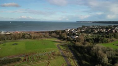 Paignton, Torbay, Güney Devon, İngiltere: DRONE VieWS: Torbay VeloPark 'ta, arka planda Torbay silueti ve Torbay kıyı şeridi bulunan bir bisiklet yarışı düzenleniyor. Torbay, İngiltere 'nin popüler bir tatil beldesidir (Clip 1). 