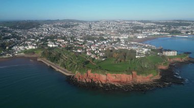 Roundham Head, Torbay, South Devon, England: DRONE VIEWS: The drone focuses on Roundham Head showing the town of Paignton and Paignton Pier in the background. Torbay is a popular UK holiday destination and a magnet for water sports enthusiasts. clipart