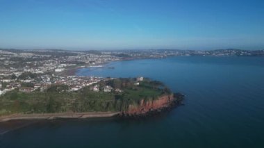 Torbay, Devon, İngiltere: Drone Roundham Head 'in etrafında Paignton, Paignton Pier, Torbay, Torquay ve Thatcher Rock' ı gösteriyor. Torbay popüler bir İngiltere tatil beldesi ve su sporları ve yelkencilik meraklıları mıknatısı (Clip 1).