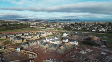 Paignton, Güney Devon, İngiltere: DRONE VİEWS: White Rock 'ta yeşil kuşak arazisinde yapım aşamasında olan yeni bir inşaat evi. Sahil kenti Paignton büyük konut ve ticari kalkınma sürecinden geçmektedir (Clip 9).