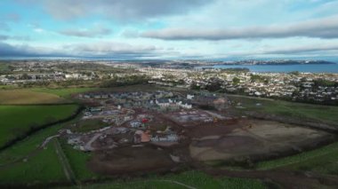 Paignton, Güney Devon, İngiltere: DRONE VİEWS: White Rock 'ta yeşil kuşak arazisinde yapım aşamasında olan yeni bir inşaat evi. Sahil kenti Paignton 'da büyük konut ve ticari gelişmeler yaşanıyor (Klip 6).