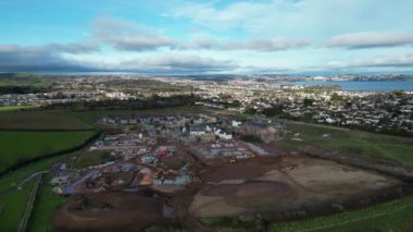 Paignton, Güney Devon, İngiltere: DRONE VİEWS: White Rock 'ta yeşil kuşak arazisinde yapım aşamasında olan yeni bir inşaat evi. Sahil kenti Paignton büyük çaplı konut ve ticari kalkınma sürecinden geçmektedir (Klip 1).