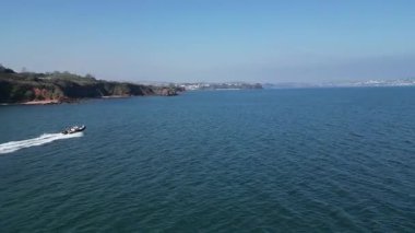 Torbay, Güney Devon, İngiltere: Bir sürat teknesi körfezi geçip Torquay 'a doğru ilerliyor. Torbay, İngiltere 'de popüler bir tatil beldesi ve su sporları meraklıları için bir mıknatıs.).