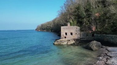 Torbay, Devon, İngiltere: İnsansız hava aracı Elberry Koyu 'ndaki terk edilmiş Viktorya Dönemi hamamının etrafında dönüyor. Güney Devon, güzel kıyı şeridi ve kırsal kesimiyle tanınan popüler bir İngiltere tatil beldesidir.).