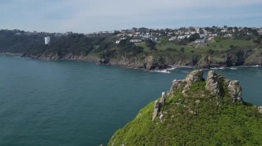 Torbay, Güney Devon, İngiltere: DRONE VİEWS: Thatcher Kayası ve arka planda anakara ve Orestone Kayası 'nı gösteren deniz. Torbay popüler bir İngiltere tatil beldesidir (8. klip).