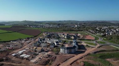 Paignton, Güney Devon, İngiltere: DRONE VIEWS: Beyaz Kaya 'da (Inglewood) yeşil kuşak arazisinde yapım aşamasında olan yeni bir konut inşaatı. Paignton, İngiltere 'de popüler bir tatil beldesi ve birçok turistik etkinliği bulunan bir emeklilik alanıdır (Clip 11 / 12).