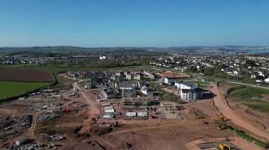 Paignton, Güney Devon, İngiltere: DRONE VIEWS: Beyaz Kaya 'da (Inglewood) yeşil kuşak arazisinde yapım aşamasında olan yeni bir konut inşaatı. Paignton, İngiltere 'de popüler bir tatil beldesi ve birçok turistik etkinliği bulunan bir emeklilik alanıdır (Clip 7 / 12).