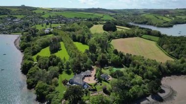 Greenway, River Dart, South Devon, İngiltere: DRONE VİEWS: DRONE Dart Nehri 'ndeki demirlemiş tekne ve mülklerin yörüngesinde dönen insansız hava aracı daireleri, B / g' deki Dittisham köyünü ortaya çıkarmaktadır. Güney Devon, İngiltere 'de popüler bir tatil beldesidir.).