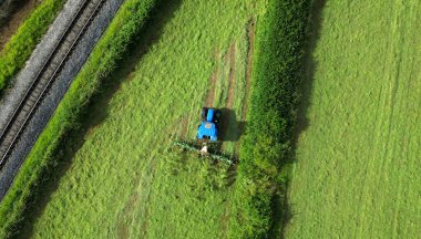 Broadbay, Torbay, Güney Devon, İngiltere: DRONE ViEW: Çayırları harmanlayan bir çiftlik traktörü manzarası. Devon önemli bir tarıma elverişli tarım bölgesidir (Fotoğraf: 1 / 2).